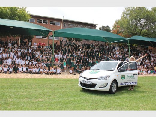 Craighall Primary School pupils cheer their principal, Andrea Prout-Jones, as they view the sponsored car.