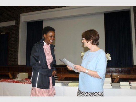 Akani Khumalo receives a prize from Mary Williams.