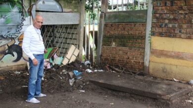 Dr Sandy Goldbaum stands in front of a blocked stormwater drain