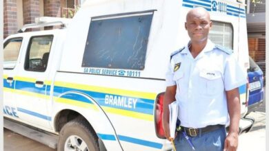 Police Captain, Captain Molefe Mogodi posing in front of a police vehicle