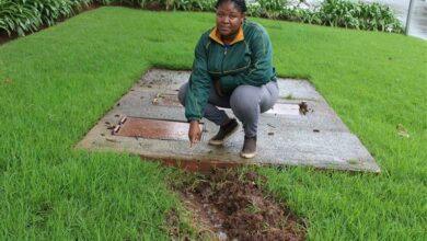 Journalist Amogelang Mphago stands on the leaking drain