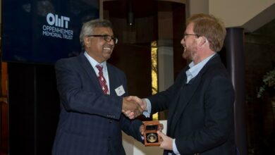 Sunil Maharaj happily accepts his appreciation award from Jonathan Oppenheimer.