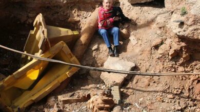 A local resident, Joy Kanter demonstrates the depth of the dug-up hole by siting in it. Photo: Asanda Matlhare