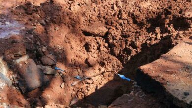 A dug-up hole is left with an electricity cable inside.