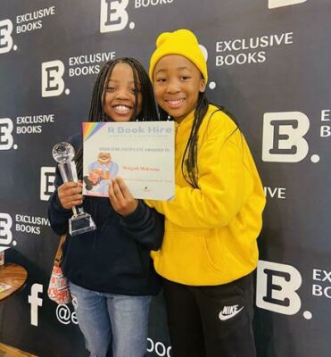 Super reader Mokgadi Mokwena receives an award from R Book Hire founder Reamoleboha Monethi.