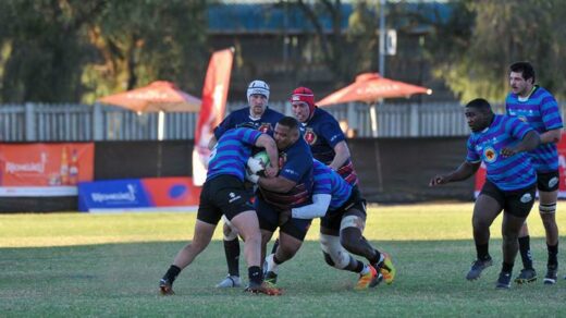 NWU players in blue and black put the pressure hard on Pirates rugby player to surrender the ball. Photo: Patrick Donoghue