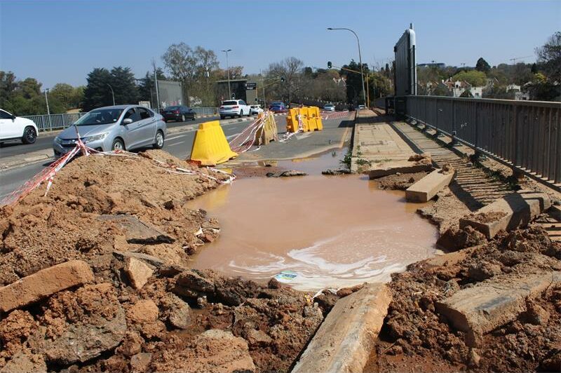 The burst pipe on Glenhove Road and Central Street crosses beneath the M1 highway bridge, supplying Houghton Estate, Melrose, and Rosebank.