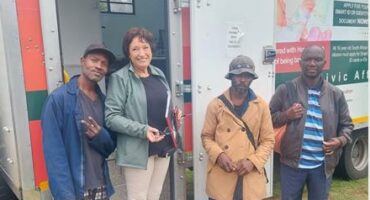 Cross the Divide volunteer, with displaced individuals by the Home Affairs mobile unit in September 2025. Photo: Supplied