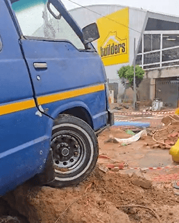 A taxi carrying passengers swerved into the excavation as planned repairs are delayed by rain.