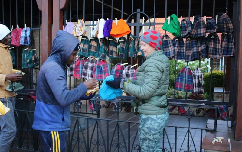A volunteer hands out beanies to a customer at St Columba's Presbyterian Church in Parkview on May 20, 2026. Photo: Naziya Davids-Easthorpe