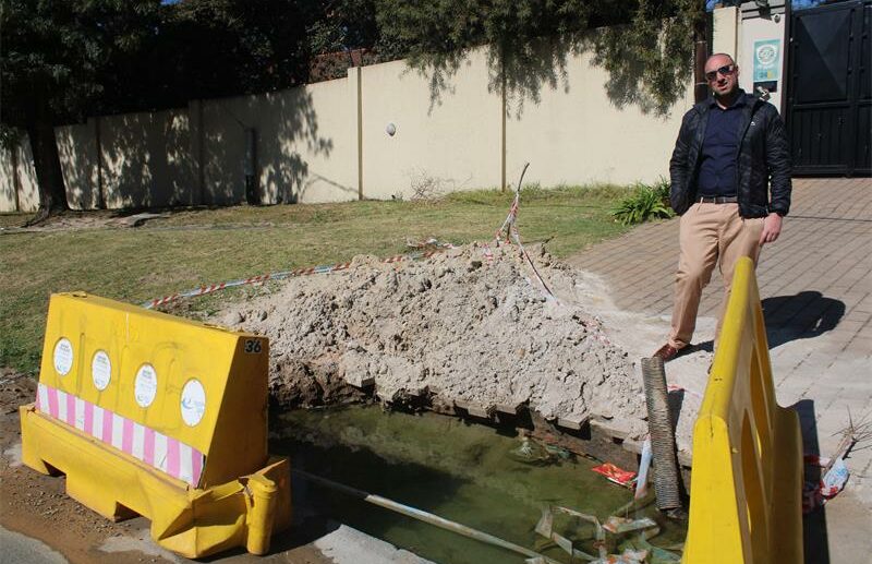 Ward 72 councillor David Schay observes observes a flooded excavation on July 2, 2026. Photo: Asanda Matlhare