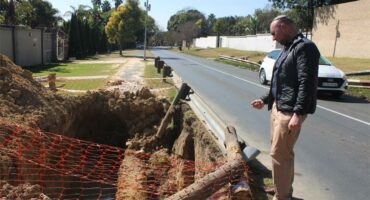 Ward 72 councillor David Schay observes an unattended excavation filled with water on July 2, 2026. Photo: Asanda Matlhare