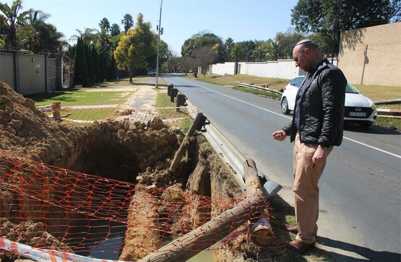 Ward 72 councillor David Schay observes an unattended excavation filled with water on July 2, 2026. Photo: Asanda Matlhare