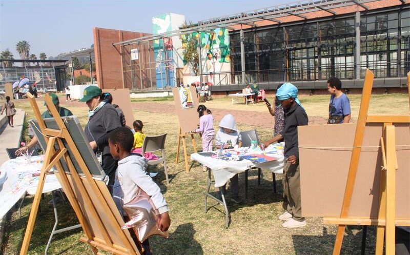 Volunteers, parents, and kids have a good time being artistic at the painting station on July 25, 2026. Photo: Thato Modopi