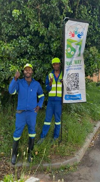 Two members of the Pave the Way community initiative work to clean and restore pavements along major routes, providing employment and purpose for displaced individuals. Photo: Supplied