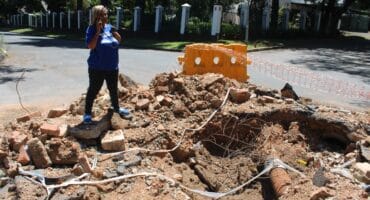 Ward 74 councillor Belinda Echeozonjoku observes leak on Corlett Drive. Photo: Asanda Matlhare on October 13, 2026. Photo: Asanda Matlhare