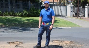 Ward 72 councillor Daniel Schay stands in between the new potholes that have emerged on Northfield Avenue. Photo taken on October 26, 2026 by Asanda Matlhare