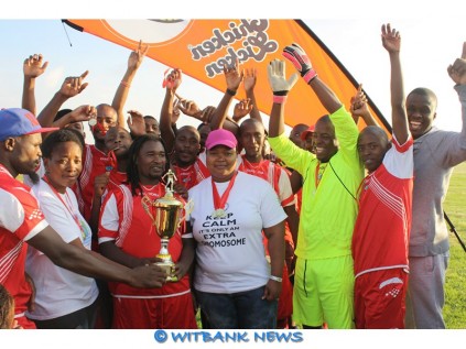 Captain of Live Life Centre, Happy Mahlangu, receives the trophy from Ms Lerato Mokoena. They beat Umilio Wevangeli 4-2 in the finals during World Down Syndrome Awareness Day, commemorated at Schoongezicht sports ground on March 21.