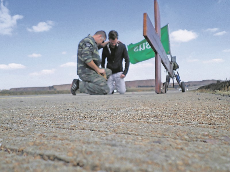Werner praying for someone on the side of the road as he walked to eMalahleni.