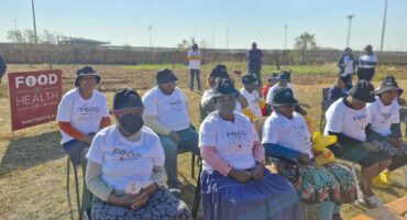 The community listen cheerfully to the speakers.