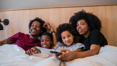 Family watching a movie on bed at home.
