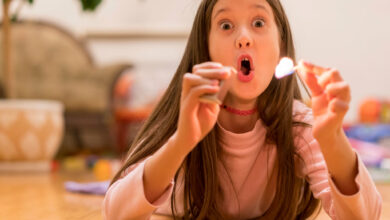 Girl playing with matches. Dangerous situation at home. A small child plays with matches, a fire, a fire flares up, danger, child and matches, lucifer match