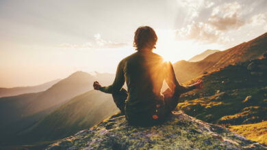 Man meditating yoga at sunset mountains Travel Lifestyle relaxation emotional concept adventure summer vacations outdoor harmony with nature