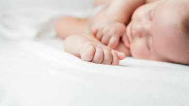 Newborn baby sweet sleeping on a white bed