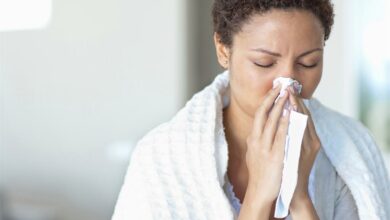 Sick woman blowing her nose