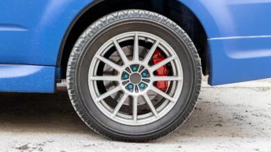 Stylish blue car wheel with red brake caliper and five-nut rim. Brake system support