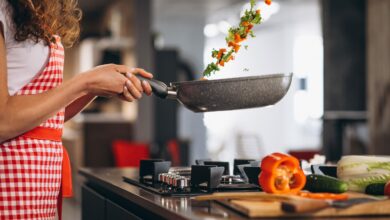 Woman chef cooking vegetables in pan