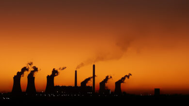 Silhouette of Matla Power Station against an orange sky at sunset.