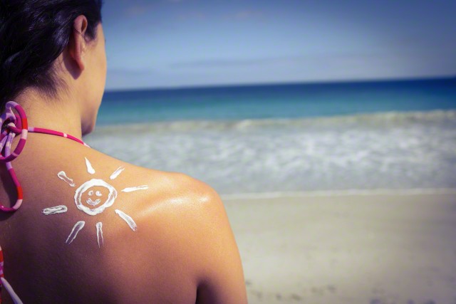 Brunette with sun tan lotion on her shoulder