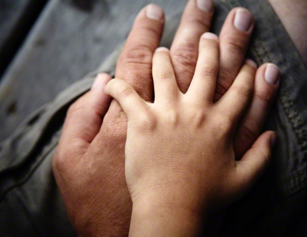 Close up of father and sons hands touching