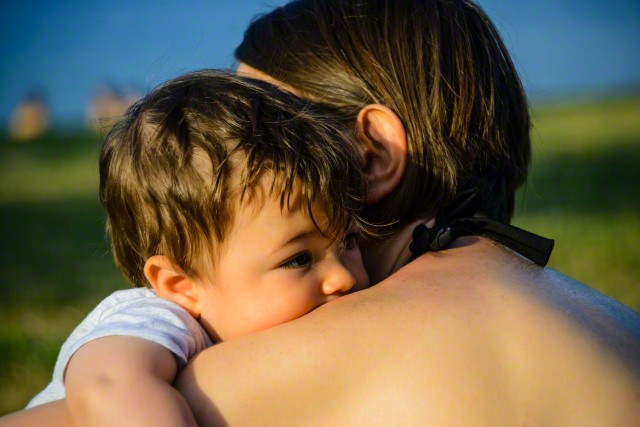 Mother Hugging Baby Boy by Lake, Italy
