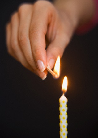 Woman lighting a birthday candle