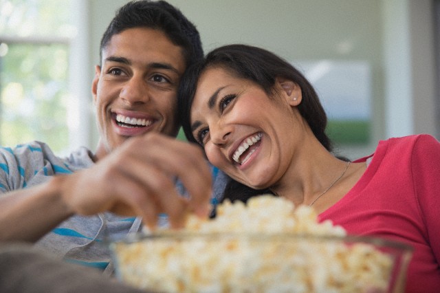 Young heterosexual couple eating popcorn