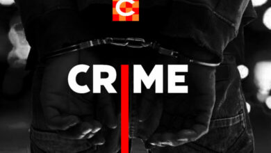 Black and white closeup of someone's hands in cuffs.