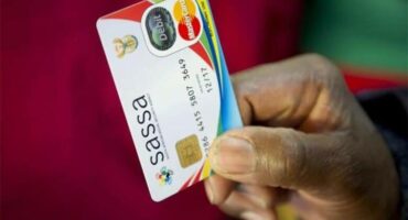 Hand holding a SASSA beneficiary card