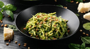 Trofie pasta with creamy spinach sauce and toasted pine nuts