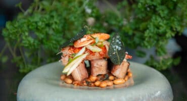 Poached lobster and pork belly served on cannellini beans