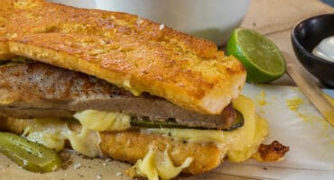 Pork belly Cuban sarmie with dipping sauce and extra pickles