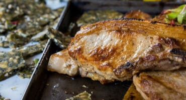 Coconut and garlic pork chops with roasted carrots and seed brittle