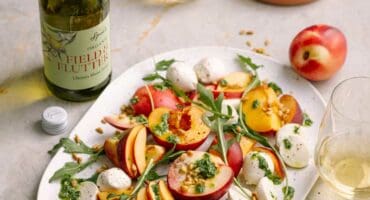 Stone fruit Caprese salad with bocconcini and basil pesto drizzle 