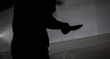 silhouette of man holding a knife