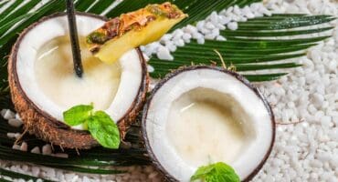 Piña colada cocktail recipe served in a coconut