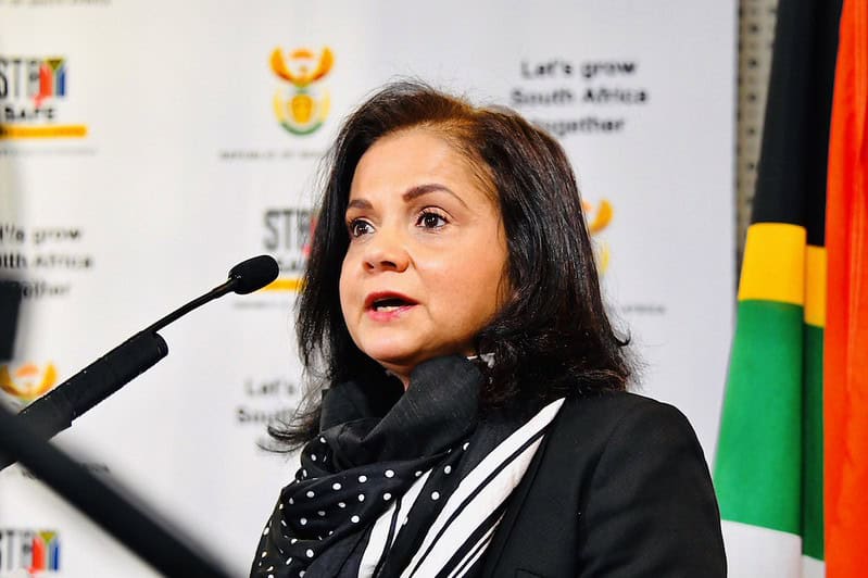Shamila Batohi speaking into a microphone. In the background government branding is visible.