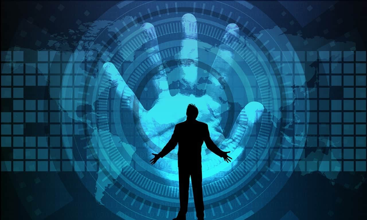 Silhouette of a man in a suit with outstretched arms against a digital background featuring a large hand and global motifs.