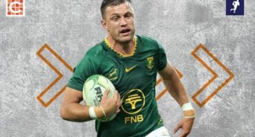 The Springboks player Handré Pollard running with a rugby ball in his arm.