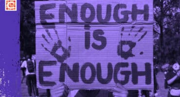 A cardboard sign saying "Enough is Enough" is held up at a protest. Handprints flank the text. The scene is tinted purple, with people in the background.